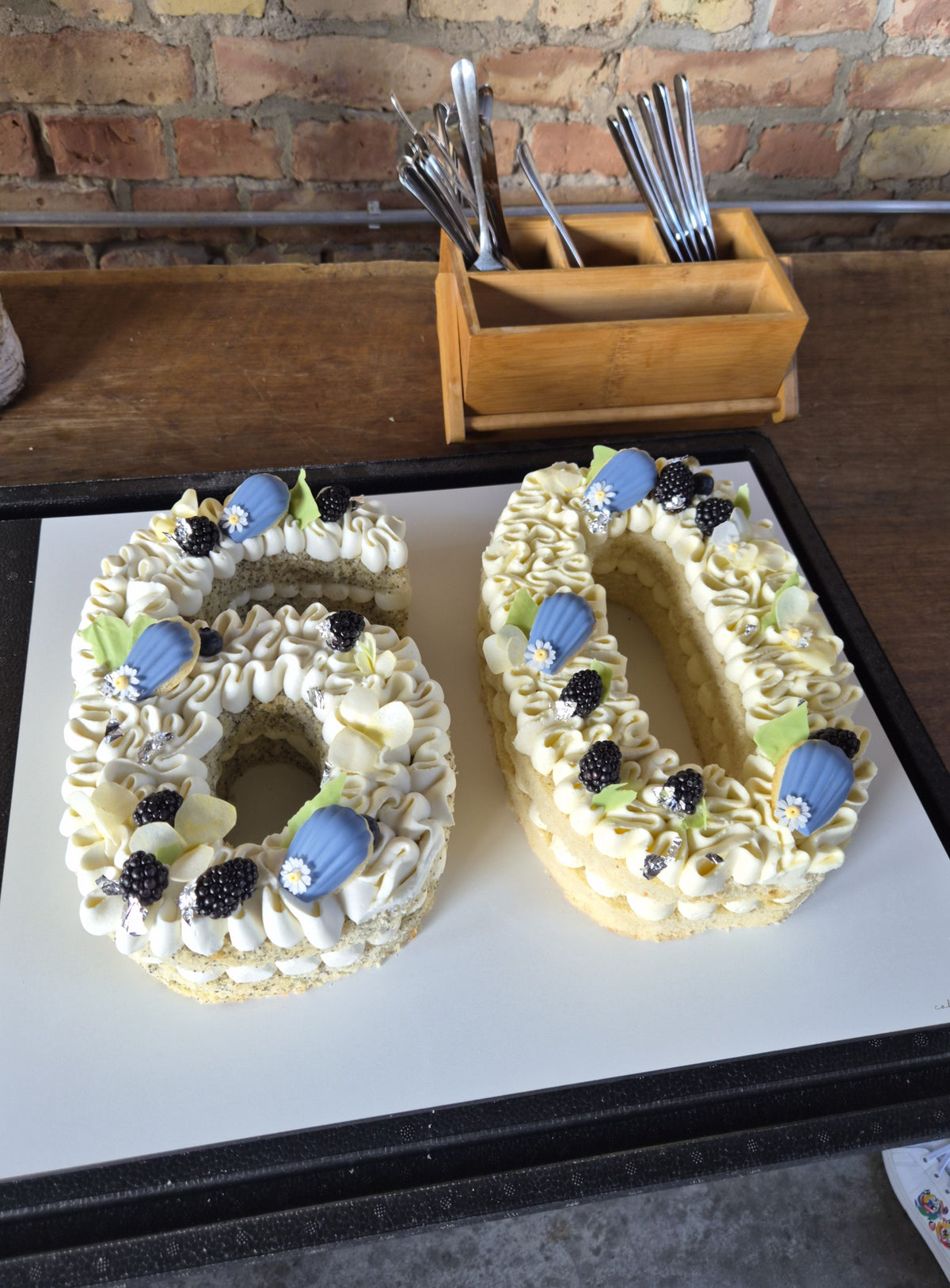 Zahlentorte zum 60. Geburtstag mit heller Creme, blauen Macarons und Beeren